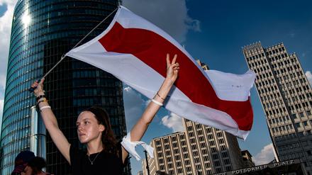  Viktoria steht mit der Fahne von Belarus auf dem Potsdamer Platz. Dort demonstrierten mehr als 100 Menschen gegen die Verletzung der Menschenrechte in Belarus - am Wochenende sollen es 1000 werden.