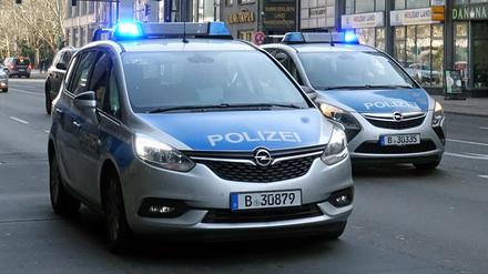 Zwei Polizeiautos fahren durch Berlin. (Symbolbild)