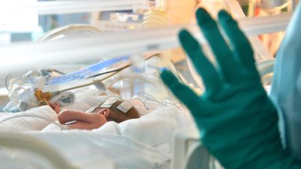 Ein Baby liegt in der Neonatologie in einem Inkubator. 