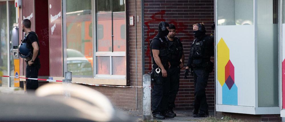 Polizeibeamte stehen in einer Einfahrt eines Gebäudekomplexes an der Goebenstraße.