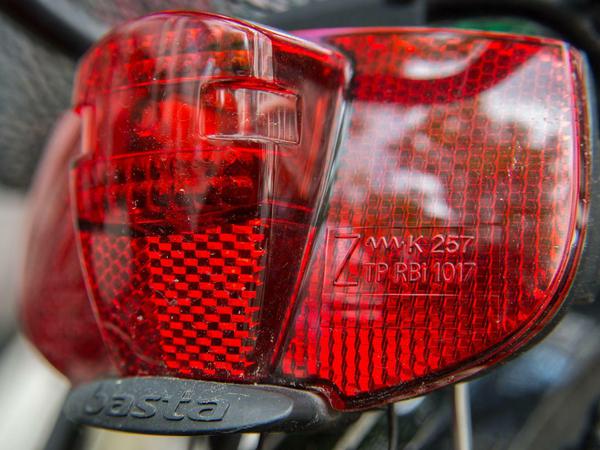 Wichtig, damit Radfahrer im Dunkeln und in der Dämmerung möglichst schnell gesehen werden - Rücklicht mit rotem Reflektor. Rechts ist die Prüfnummer des Kraftfahrt-Bundesamtest zu erkennen. 
