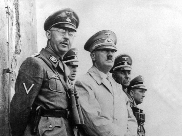Adolf Hitler (Mitte) neben dem Reichsführer der SS, Heinrich Himmler (links). Der Wahlspruch der SS geht auf Hitler selbst zurück.