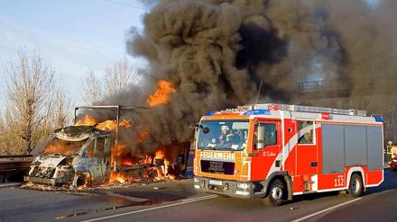 Ob da noch was zu retten ist? Die Feuerwehr versucht es wenigstens. Am 25. November 2011 brennt auf der A100 ein Kleinlaster.