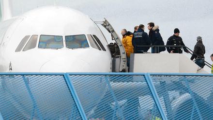 Abgelehnte Asylbewerber besteigen ein Flugzeug.
