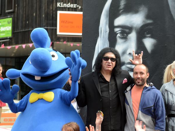 Kiss-Bassist und -Sänger Gene Simmons besichtigt das Mauerteil Malala" vor dem FEZ in Berlin-Köpenick. Victor Landeta, neben Simmons, hat das Mauerteil im Rahmen des Projektes Die Erde mein Zuhause" gestaltet.