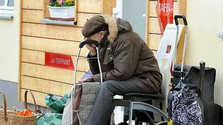 Ein ältere Mann wartet vor einer Tafel auf sein Mittagessen (Archivbild). In Berlin und Bremen ist der Anteil der Personen, die auf soziale Mindesthilfe angewiesen sind, besonders groß.