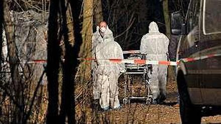 Gerichtsmediziner transportieren den Babyleichnam in einem Waldstück in Hellersdorf ab. Es wurde von einer Spaziergängerin entdeckt.