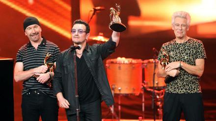 Zurück in Berlin: Bono (Mitte) und seine Weggefährten von U2, The Edge (links) und Adam Clayton (rechts) mit ihren Bambis.