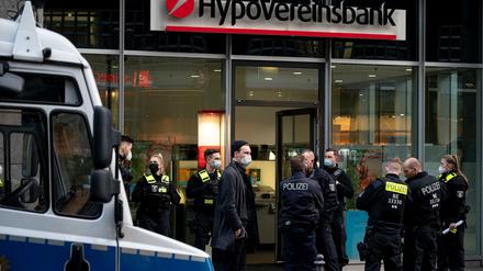Polizisten stehen vor der Hypovereinsbank in der Friedrichstraße. Bankräuber haben die Bank überfallen und mehrere Menschen mit Reizgas verletzt.