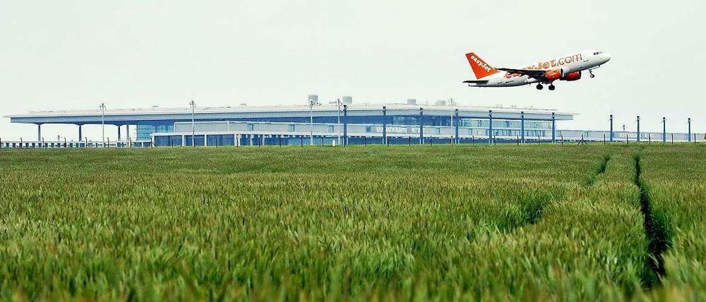 Eine Maschine der Fluglinie Easyjet passiert in Berlin während der Startphase das neue Terminal des Flughafens BER in Schönefeld (Brandenburg). 