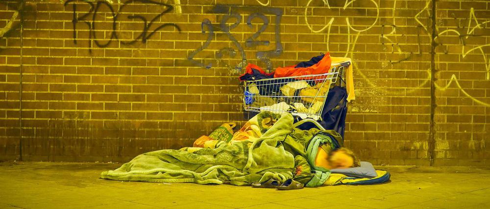 Eine obdachlose Person schläft am Bahnhof Zoologischer Garten.