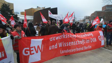 Demonstranten mit einem Banner der GEW demonstrieren vor der Philharmonie.