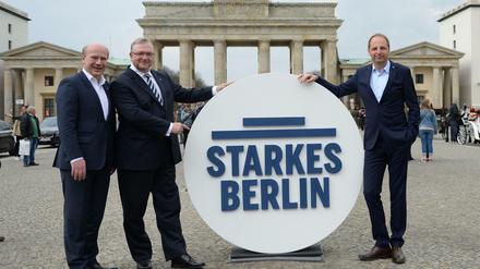 Wahlkampfleiter Kai Wegner (CDU, l-r), Kampagnenmanager Thomas Heilmann (CDU) und der CDU-Landesvorsitzende Frank Henkel posieren vor dem Brandenburger Tor. 