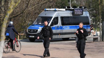 Berliner Polizisten weisen im Park am Gleisdreieck auf die Ausgangs- und Kontaktsperren hin.