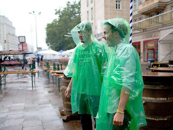 Bei starkem Regen sind zwei Besucher zu Gast beim Bierfestival in Berlin.