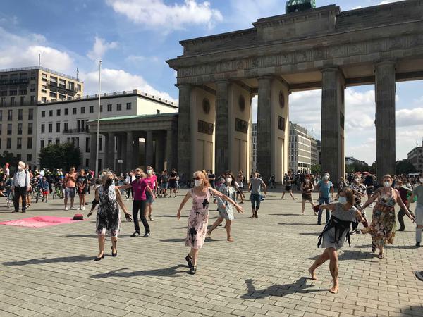 Aktivist:innen tanzen bei den Klimaprotesten in der Berliner Innenstadt.