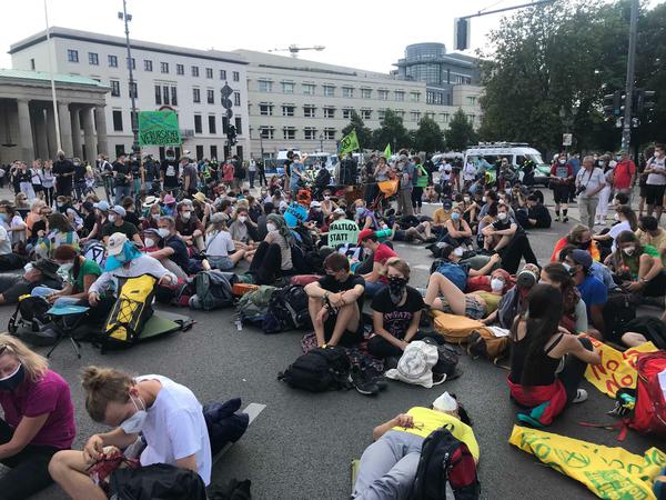Teilnehmer haben sich zu einer Sitzblockade vor dem Brandenburger Tor versammelt.