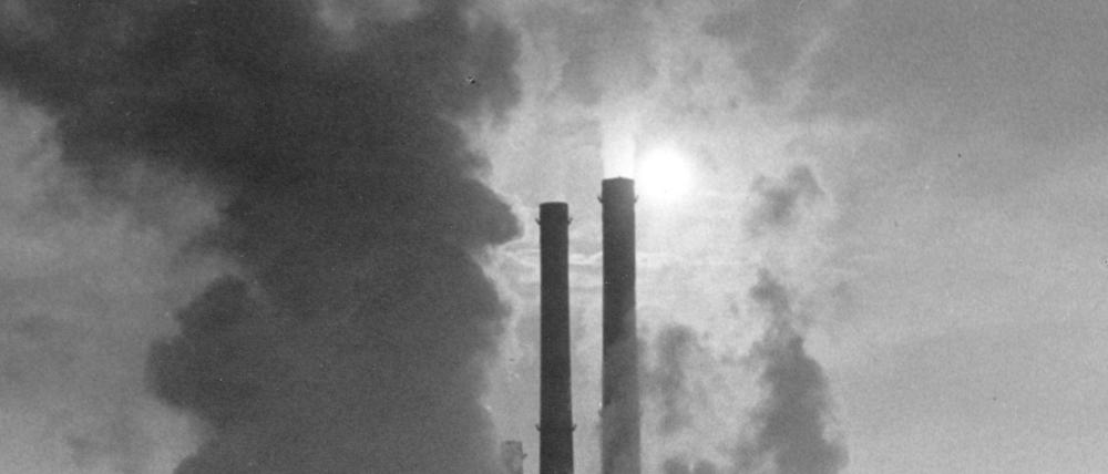 Wolken aus den Kühltürmen steigen in den dunstigen Himmel über dem Chemiekombinat Bitterfeld, ein Bild aus dem Jahr 1970.