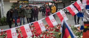 Passanten stehen am Breitscheidplatz in Berlin im Gedenken an die Opfer des Terroranschlags vom 19.12.2016