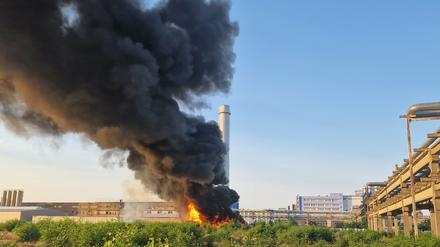 Eine schwarze Rauchwolke steigt über einem Chemiebetrieb auf. 