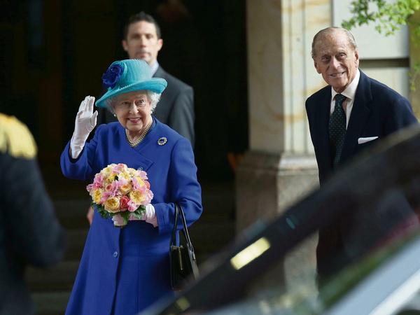 Ein Gruß für die Schaulustigen: Queen Elizabeth II. und Prinz Philip sind am Dienstagabend am Hotel Adlon eingetroffen. Am Mittwoch beginnt ihr Besuchsprogramm.