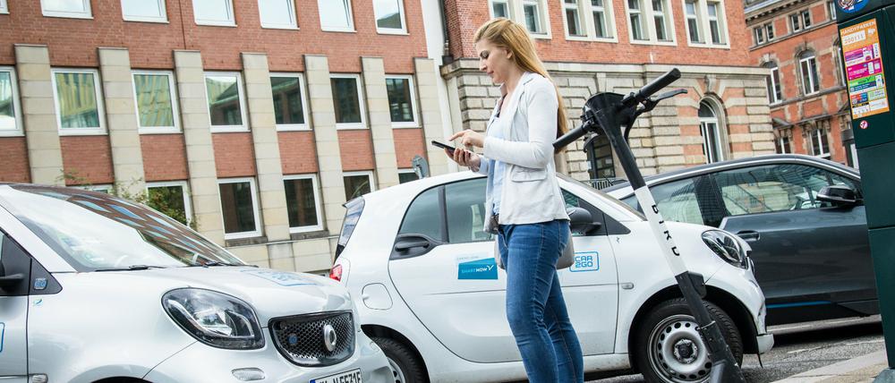 Eine Frau mietet ein Carsharing-Auto mit ihrem Smartphone 