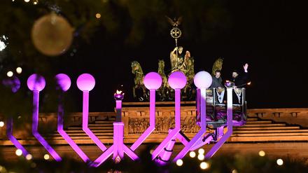 Licht im Dunkeln. Rabbiner Yehuda Teichtal (r) und Michael Müller zünden die erste Kerze am Chanukka-Leuchter vor dem Brandenburger Tor an. 