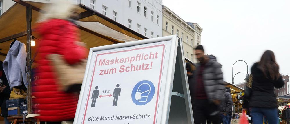 Ein Schild zu Maskenpflicht und Abstandsgebot auf dem Wochenmarkt auf dem Hermannplatz.