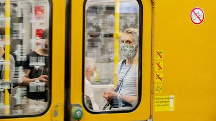 Eine Frau mit Mundschutz ist im U-Bahnhof Turmstraße in einer U-Bahn zu sehen. In Berlin gilt im öffentlichen Nahverkehr zur Eindämmung des Coronavirus die Pflicht für das Tragen einer Bedeckung von Mund und Nase.