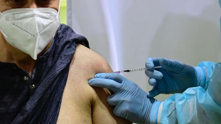 Ein Arzt setzt eine Spritze im Impfzentrum Tempelhof. Ab Samstag gibt es dazu für einige den digitalen Impf-Nachweis.