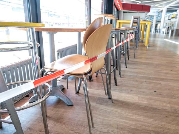 Flaute: Mit Absperrband werden die Stühle und Tische eines Geschäftes im Flughafen Tegel abgesperrt.