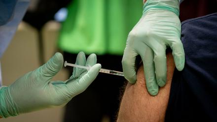 Ein Arzt impft einen Pfleger im vierten Impfzentrum in Berlin, das im Terminal C des ehemaligen Flughafens Tegel gelegen ist. Hier wurden zu Beginn vor allem Pflegekräfte und medizinisches Personal gegen das Coronavirus geimpft.