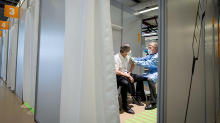 Ein Arzt bereitet im Impfzentrum in Berlin am Flughafen Tegel die Impfung eines Patienten mit dem Impfstoff von AstraZeneca vor.