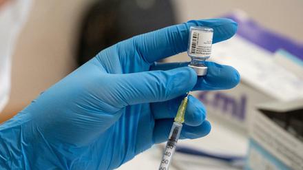 Die Mitarbeiterin eines mobilen Impfteams zieht in einem Alten- und Pflegeheim den Impfstoff von Biontech/Pfizer in eine Spritze auf.