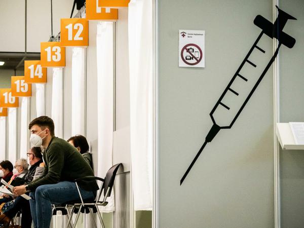 Menschen warten im Corona-Impfzentrum auf dem Messegelände in Berlin auf ihre Impfung. 