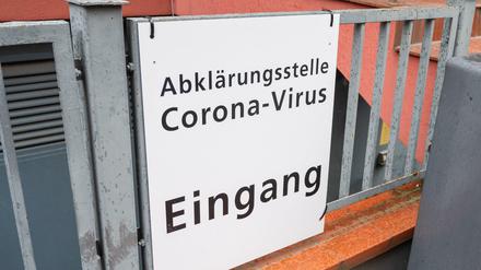 Schild an Zaun mit der Aufschrift: Abklärungsstelle Corona-Virus, Eingang.