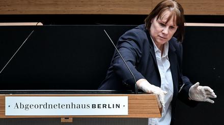 Stille Heldin: Eine Mitarbeiterin reinigte bei der Plenarsitzung am Donnerstag nach jedem Redebeitrag das Pult im Abgeordnetenhaus.