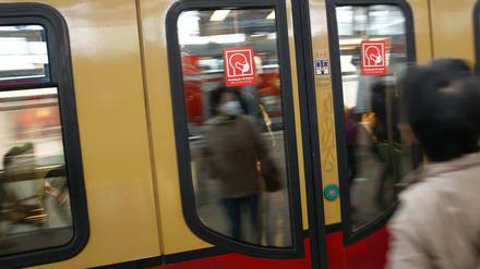 Rote Schilder weisen auf der S-Bahn Tür auf die Pflicht zum Tragen einer Maske hin. 