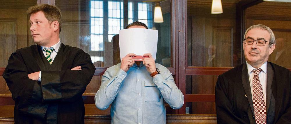 Der wegen Mordes angeklagte Hamdi H. steht am 27. Februar 2017 neben seinen Verteidigern in einem Verhandlungssaal des Landgerichts Berlin. 
