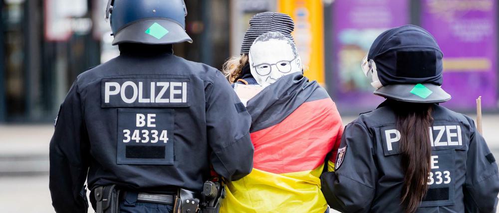 Polizisten führen bei einer Demonstration gegen die Corona-Maßnahmen auf dem Alexanderplatz eine Frau ab.