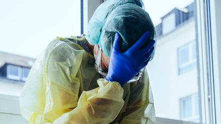 Aufreibende Arbeit: Ein erschöpfter Krankenhaus-Mitarbeiter in Schutzkleidung gegen eine Corona-Infektion. (Symbolbild)