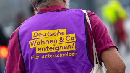 Ein Teilnehmer der Demonstration der Gewerkschaften zum Tag der Arbeit trägt eine Weste mit der Aufschrift "Deutsche Wohnen Co enteignen!".