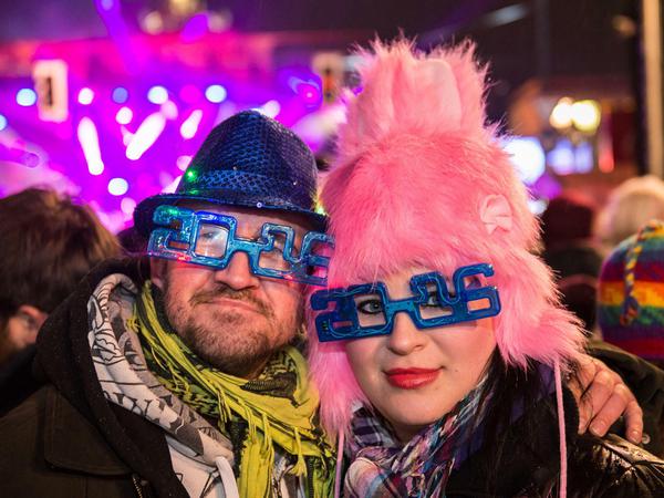 Carsten und Vivien tragen bei der Silvesterparty am Brandenburger Tor in Berlin Brillen in Form der Jahreszahl 2016. 