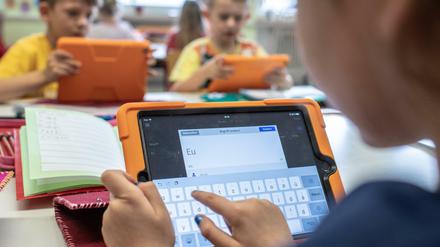 Grundschüler arbeiten mit Tablets.
