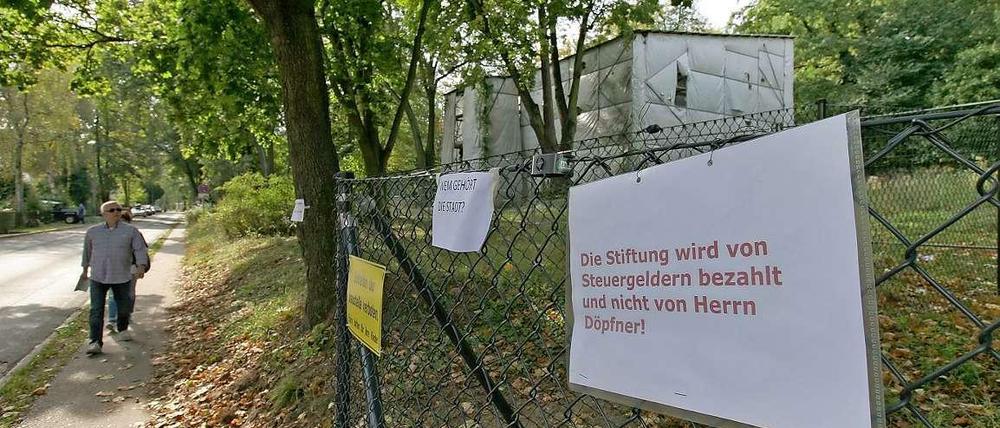 Streit unter Nachbarn. Mit Schildern wird gegen den Zaun protestiert, den Mathias Döpfner im Auftrag der Schlösserstiftung um die Gärten der Villa Henckel und der Villa Schlieffen errichten ließ. 