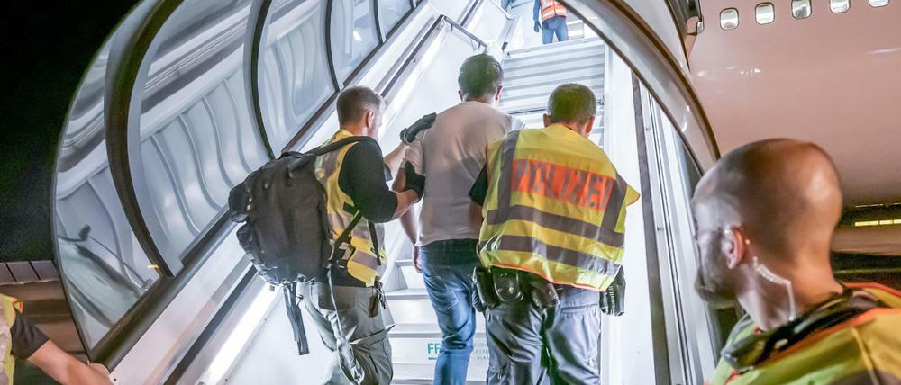 Polizeibeamte begleiten einen Afghanen auf dem Flughafen Leipzig-Halle in ein Charterflugzeug (Symbolbild).