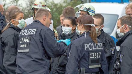 Einsatz nur mit Schutzmasken. Polizisten sperren das Jobcenter Pankow ab, nachdem dort eine Frau zusammengebrochen war und ein Ebola-Verdacht nicht ausgeschlossen werden konnte.
