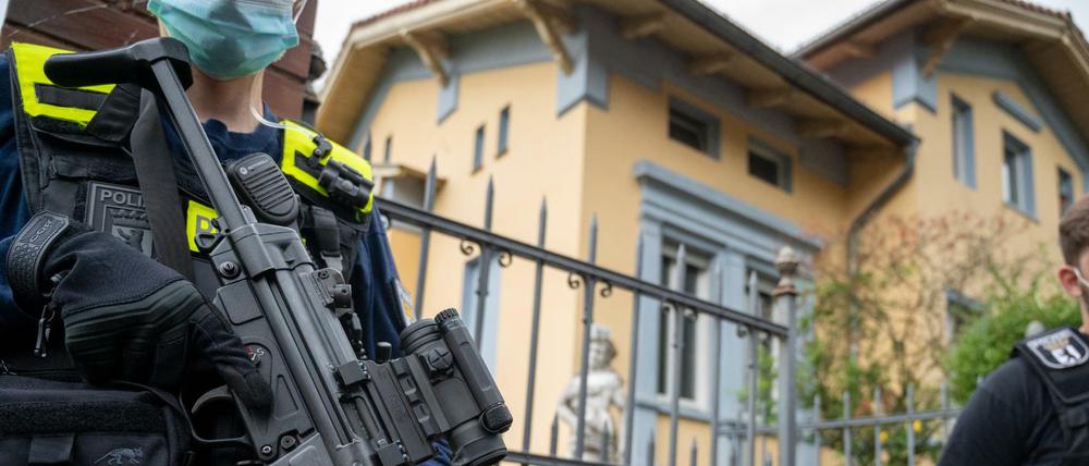 Schwer bewaffnete Polizisten stehen vor der Remmo-Villa in Alt-Buckow.