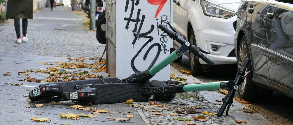E-Scooter liegen in Berlin auf einem Gehweg.