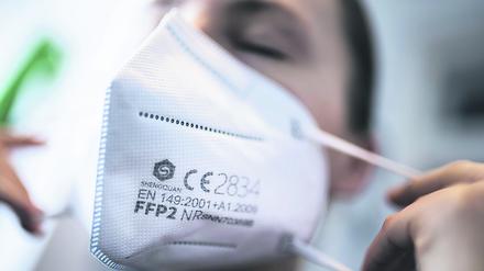 Eine Frau setzt sich in Berlin eine FFP2-Maske auf. (Symbolbild)